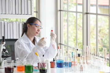 Scientists working in laboratory	,Close-up of a scientistYoung female scientist looking through a microscope in a laboratory doing research,