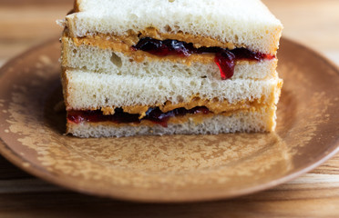 Close up view of a peanut butter sandwich with grape jelly dripping. 