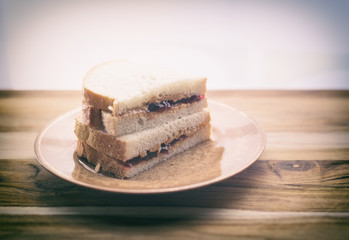 Peanut butter and jelly sandwich on a small plate, copy space. 