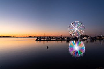 Illuminated ferris wheel at National Harbor near the nation capital of Washington DC at sunset