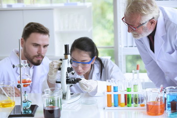 Scientists are working in science labs.Close-up of a scientistYoung female scientist looking through a microscope in a laboratory doing research