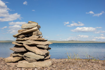 Balance stones pyramid meditation harmony similar with blue lake and sky on background