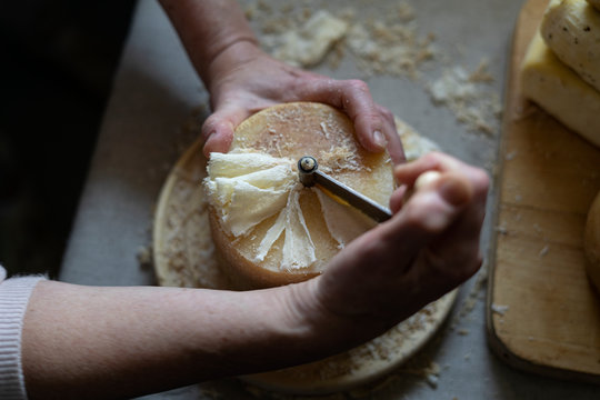 Scraping Device of Swiss Cheese Tete de moine. A man cuts cheese.