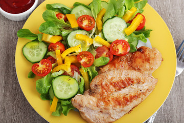 Grilled chicken breast with raw vegetables salad