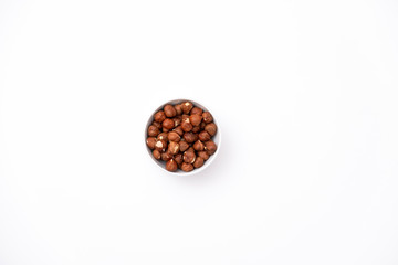 Isolated raw hazelnuts in a bowl on white background.