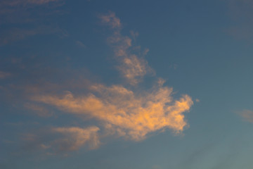 Fototapeta na wymiar Orange clouds on the blue sky