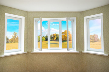 View through a opened modern PVC window onto beautiful autumn landscape