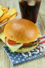 Burger with beef, fritters and glass of cola on a wood table
