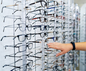 Row of glasses at an opticians. Eyeglasses shop. Stand with glasses in the store of optics. Woman's...
