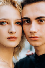 Portrait of face of loving couple. Charming blonde with wavy hair and a brunette guy
