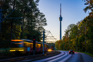 Germany, Colorful autumn trees decorating cityscape of stuttgart city street with traffic, a train...