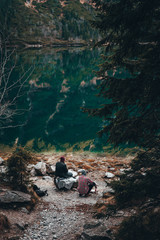 Personas disfrutando de la naturaleza en un lago en la montaña con bosque