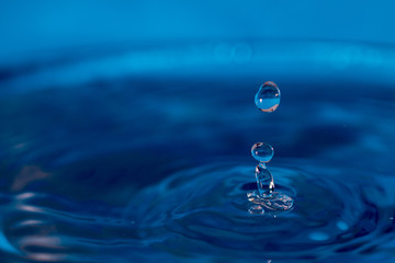 water drop splash in a blue colored glass 