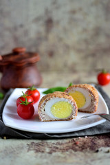 Delicious Scottish eggs cut in two. A big meatball with an egg on a nice plate.