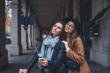 Fototapeta premium Girlfriends tourist taking photo self portrait together on smartphone mobile. Blogger travels in europe city. Vacation holiday friendship concept. Travelers self cellphone technology mockup