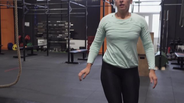 Fitness woman doing big tire flips exercise during functional training