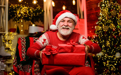 Obraz na płótnie Canvas Bearded senior man Santa Claus. Legend about Santa Claus. Merry christmas. Traditions concept. Elderly grandpa at home. Delivering gifts. Presents for family. Santa Claus relaxing in arm chair