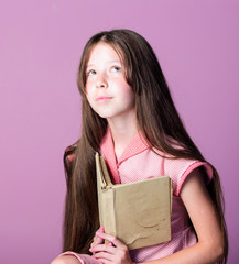 Fototapeta premium dreaming. novel for girl. Copy space. keep her secrets in diary. book store concept. small girl read interesting story. fiction book. home education. Happy childhood. childrens literature. book lover