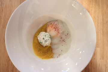 Oeuf mollet et crème de butternut dans une assiette blanche