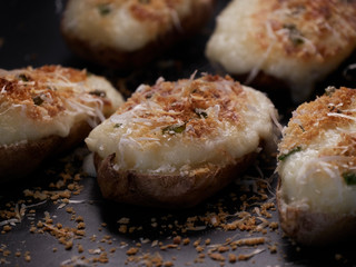Freshly cooked stuffed baked potatoes with cream cheese green onions and parmesan