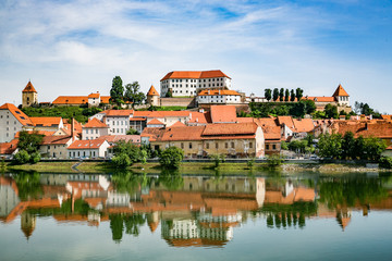 Ptuj town in Slovenia - oldest city in Slovenia. Panoramic view over Old Town and castle with a reflection in Drava River.