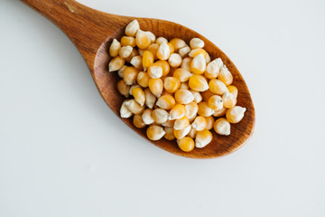 corn grains in wooden spoon
