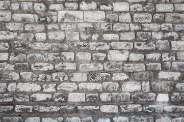 An old wall of white uneven brick.