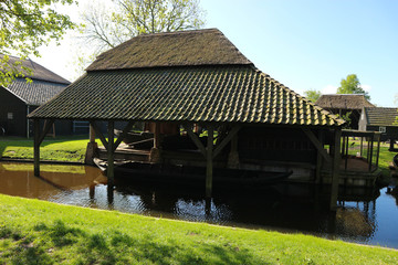 Obraz premium Dutch old wooden house with the parking place of a boat in the canal, Netherlands