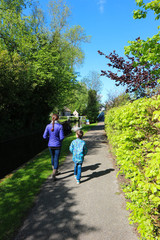 Obraz premium Tourist family mother and son walk along the canal in cosy dutch village Giethoorn, venice of the north, Netherlands