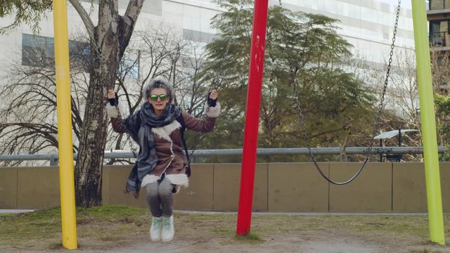Mujer sentada en un colmpio relajadamente una tarde invernal