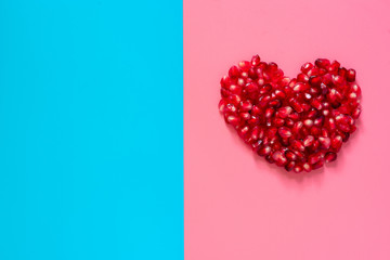 ripe and delicious pomegranate on blue and pink