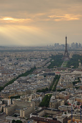 Aerial view of Paris, France. Eiffel tower in overcast sky with light rays. Polluted, dramatic ambience. Cranes in foreground