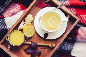 Cup of tea on red warm woolen blanket