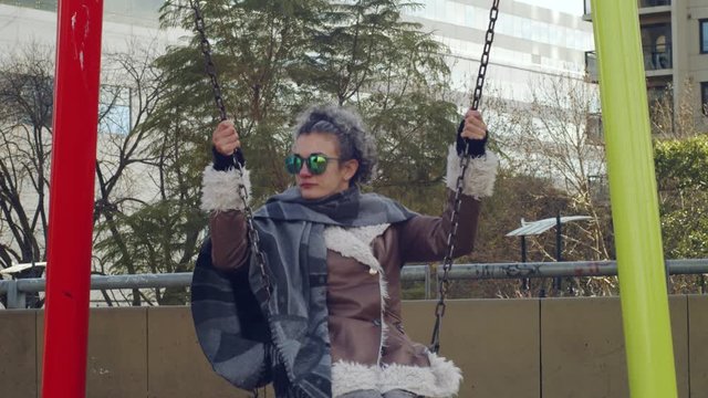 Mujer sentada en un colmpio relajadamente una tarde invernal