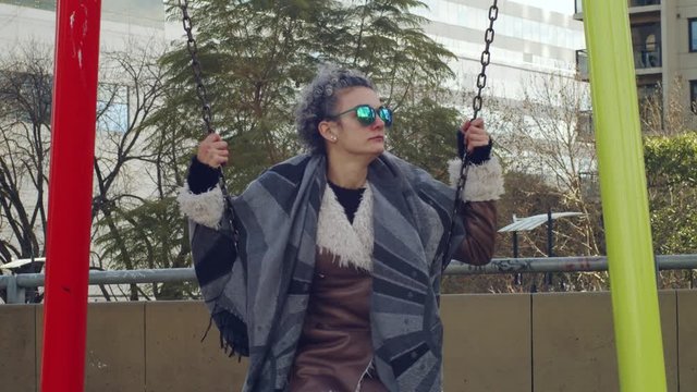 Mujer sentada en un colmpio relajadamente una tarde invernal