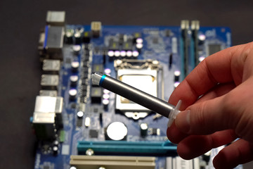 Fototapeta na wymiar Drawing thermal paste on computer processor. Installing a cooling system on a CPU processor