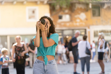 Fototapeta premium Girl tourist or professional photographer who shoots in a typical Italian city, Europa, Verona