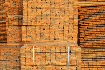 Wooden boards are piled in stacks at the backyard of a construction supermarket. Industrial background, lumber, industrial wood. Pine wood timber for furniture production 