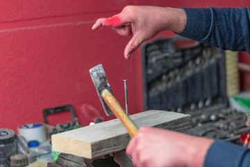 man is trying to hammer a nail. missed and hit my fingers. finger deformity.