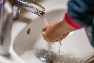 Kinderhände , die sich unter fließendem Wasser waschen