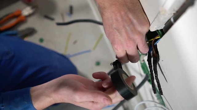 Electrician insulates wires with tape