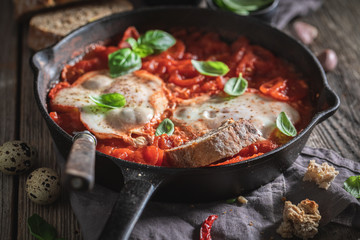 Delicious shakshuka with eggs, tomatoes and herbs