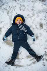 Fototapeta na wymiar The boy lies in the snow