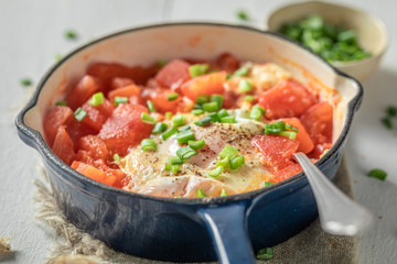 Spicy shakshuka with tomatoes, eggs and herbs