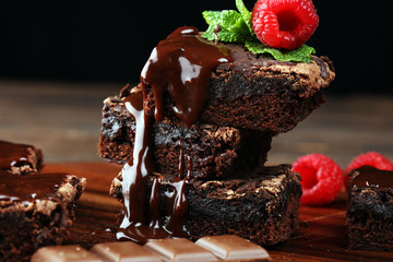 chocolate brownie cake dessert with raspberries and spices on a wooden background.