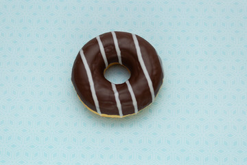 donut on blue with triangular pattern background, top view