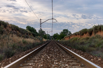 Unique railroad line at the sunset. Train railway track . Low clouds over the railroad.