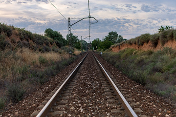 Unique railroad line at the sunset. Train railway track . Low clouds over the railroad.