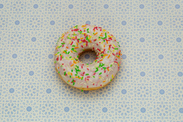 donut on gray with blue pattern background, top view