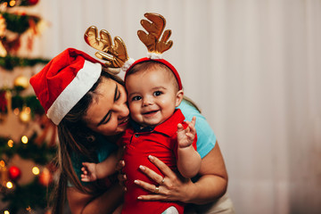 Mother and her baby playing at home on Christmas holiday